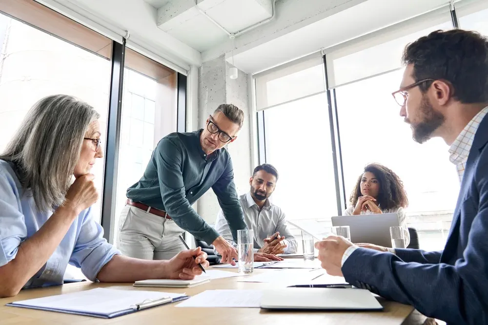 Male mature caucasian ceo businessman leader with diverse coworkers team, executive managers group at meeting. Multicultural pro